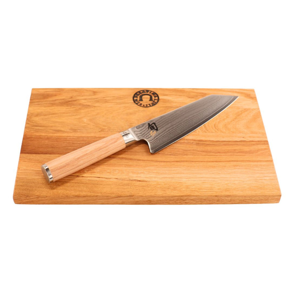 Das Kai Shun Classic White Kiritsuke - Limitierte Edition (5.555 St.) mit Holzgriff wird auf einem Schneidebrett aus Eiche mit natürlicher Holzmaserung und einem Logo in der oberen Mitte präsentiert.