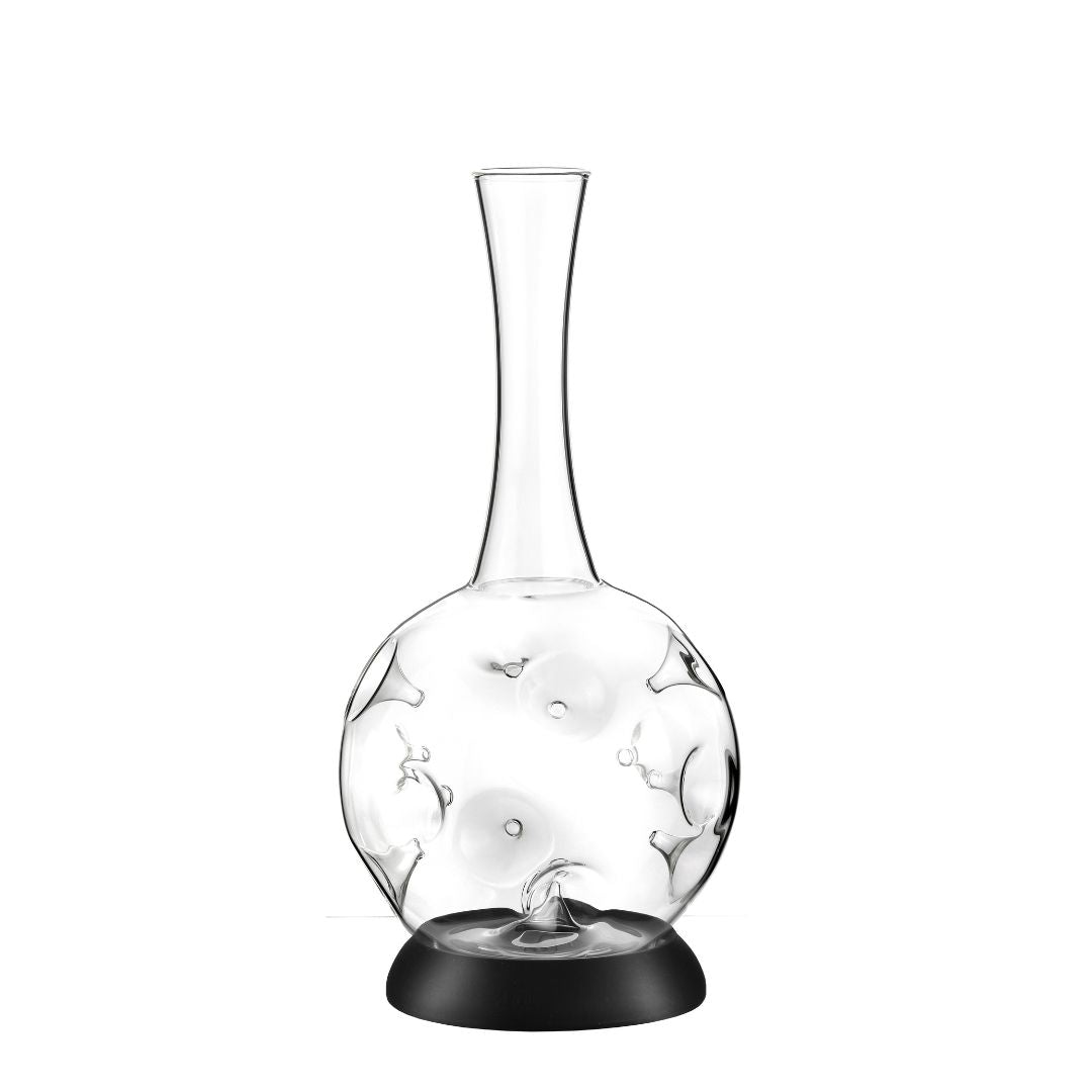 Der Weindekanter "Eddy" - 1,5L Karaffe aus Borosilikatglas von Zieher zeigt ein innovatives Design mit hohem, schmalem Hals, rundem Boden und künstlerischen Vertiefungen, stehend auf schwarzer runder Basis.