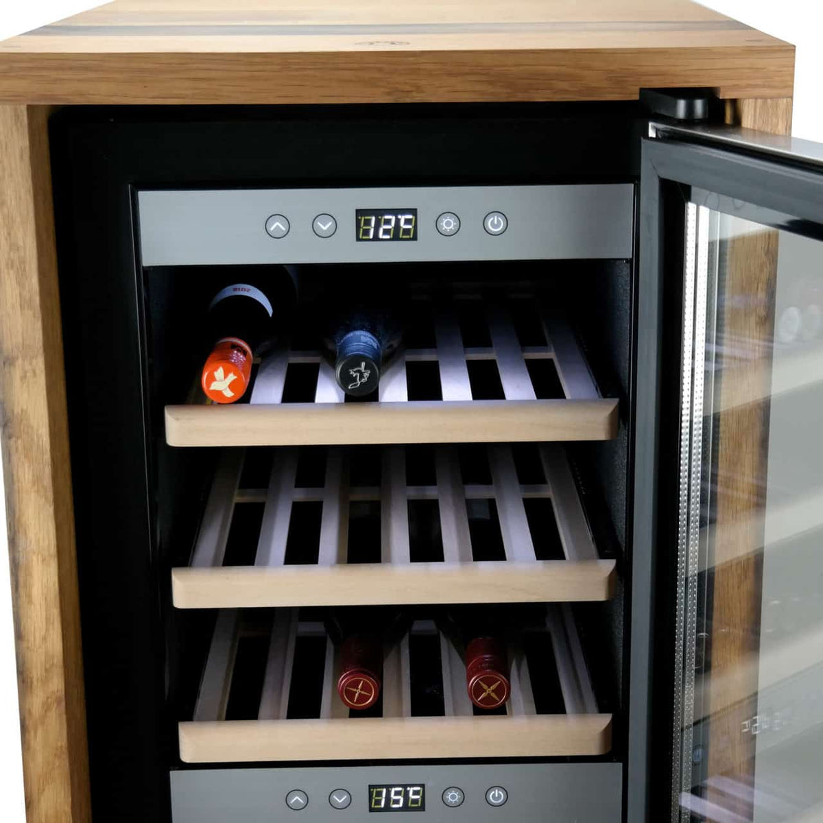 Ein hölzerner Weinkühler mit Glastür steht leicht geöffnet und gibt den Blick auf drei Regale aus Holzlatten frei. Auf jedem Regal liegen mehrere Flaschen Wein horizontal. Auf der oberen Tafel sind die Temperatureinstellungen zu sehen.