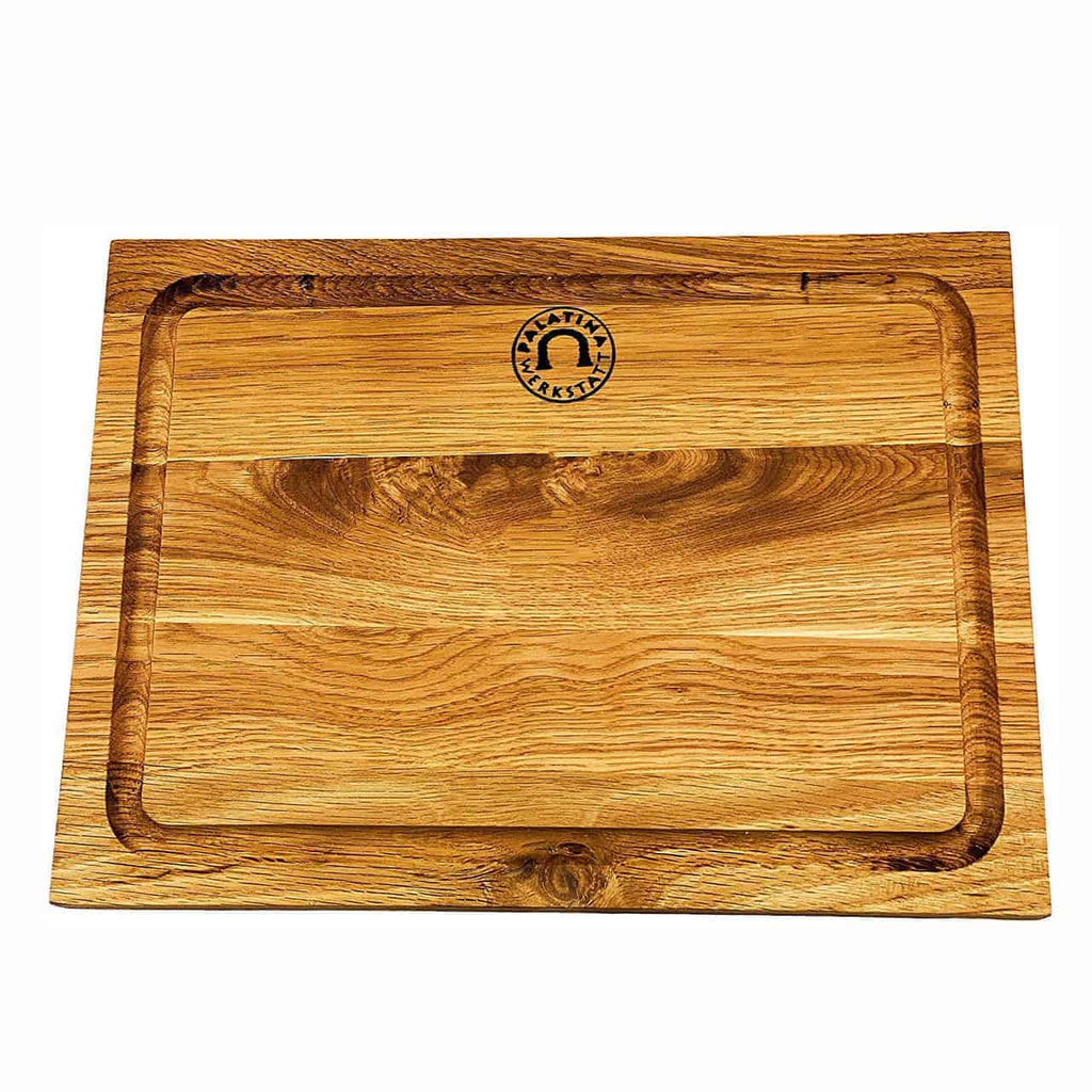 Ein Kai Shun Premier Minamo TMM-0700 Schneidebrett aus Eiche, 30 x 22 cm groß, mit geriffelten Kanten und einem eingravierten runden Logo in der oberen Mitte, ideal zur Kombination mit Ihrer Kai Shun Premier-Kollektion. Das Brett weist eine natürliche Holzmaserung auf und hat eine hell- bis mittelbraune Oberfläche.