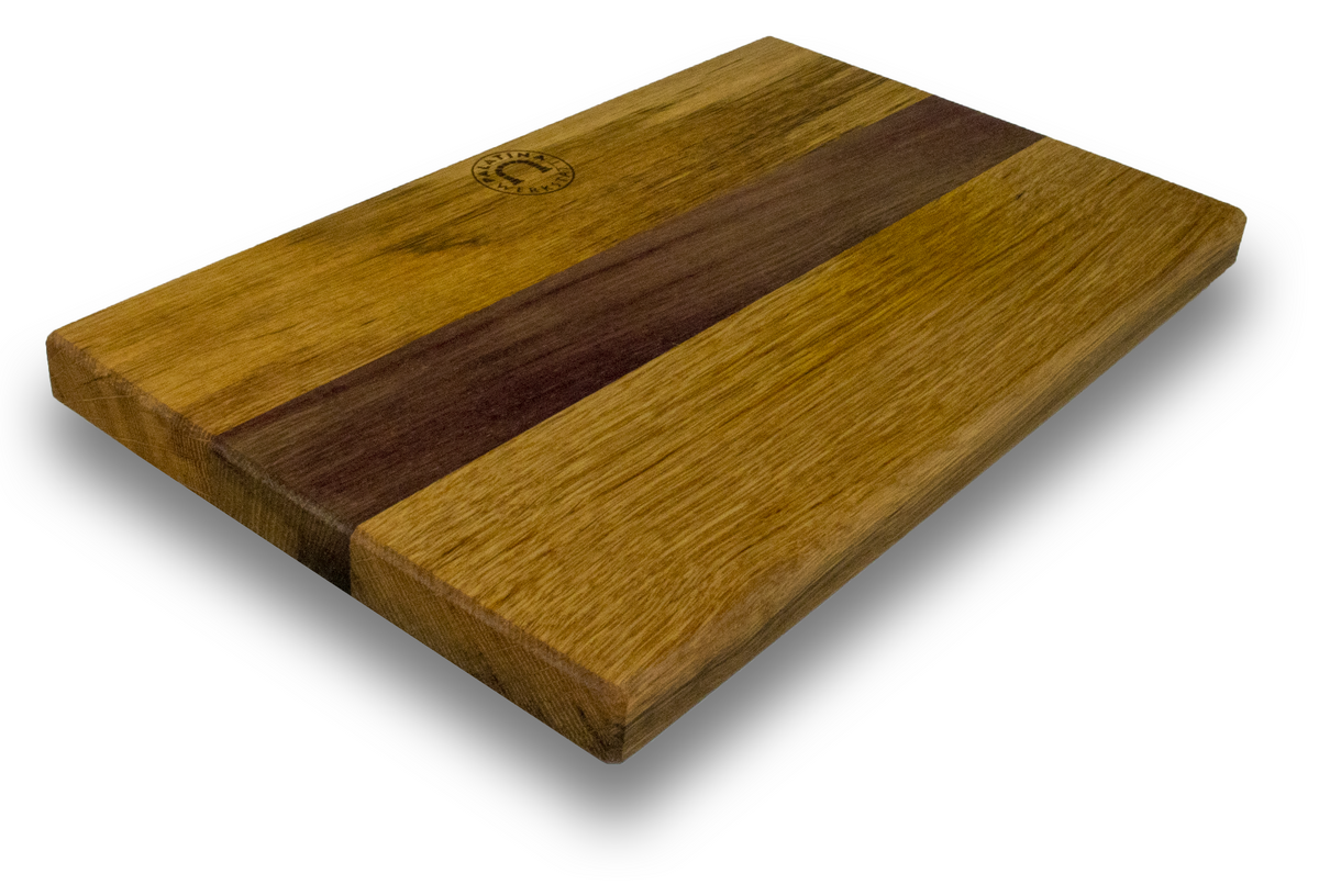 Ein rechteckiges Fassholzbrett im Format 34 x 21 cm mit einem hellen und dunklen Holzstreifendesign. Das Brett hat eine glatte Oberfläche mit einem kleinen, runden Logo in der oberen linken Ecke. Es ist schräg positioniert, sodass seine Dicke sichtbar ist und Schatten darunter geworfen werden. Es passt perfekt zum Güde Synchros Brotmesser, das eine 32 cm lange Klinge hat.