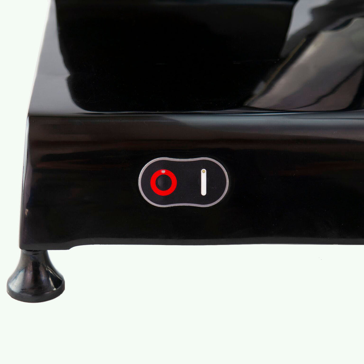 Nahaufnahme des Berkel Red Line 300 Schwarz-Geräts mit rotem Ein-/Ausschalter. Der Schalter befindet sich seitlich mittig neben Symbolen, die die Ein- (|) und Aus-Einstellungen (O) anzeigen. Der Standfuß dieser Original Profi-Aufschnittmaschine verfügt über ein kleines Standbein, das Stabilität während des Betriebs gewährleistet.