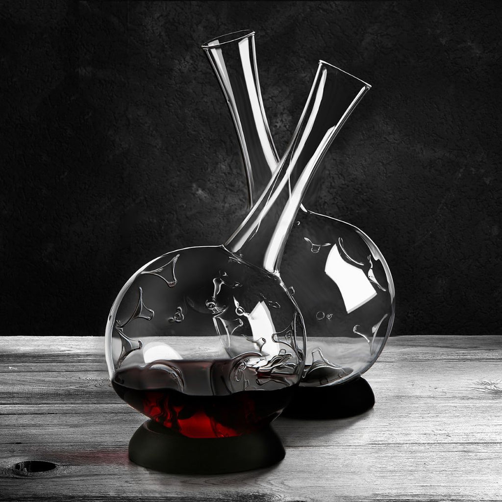 Zwei elegante Weindekanter "Eddy" 1,5L Karaffen aus Borosilikatglas von Zieher stehen auf Holz, eine gefüllt mit Rotwein. Das innovative Design und der dunkle Hintergrund heben das klare Glas eindrucksvoll hervor.