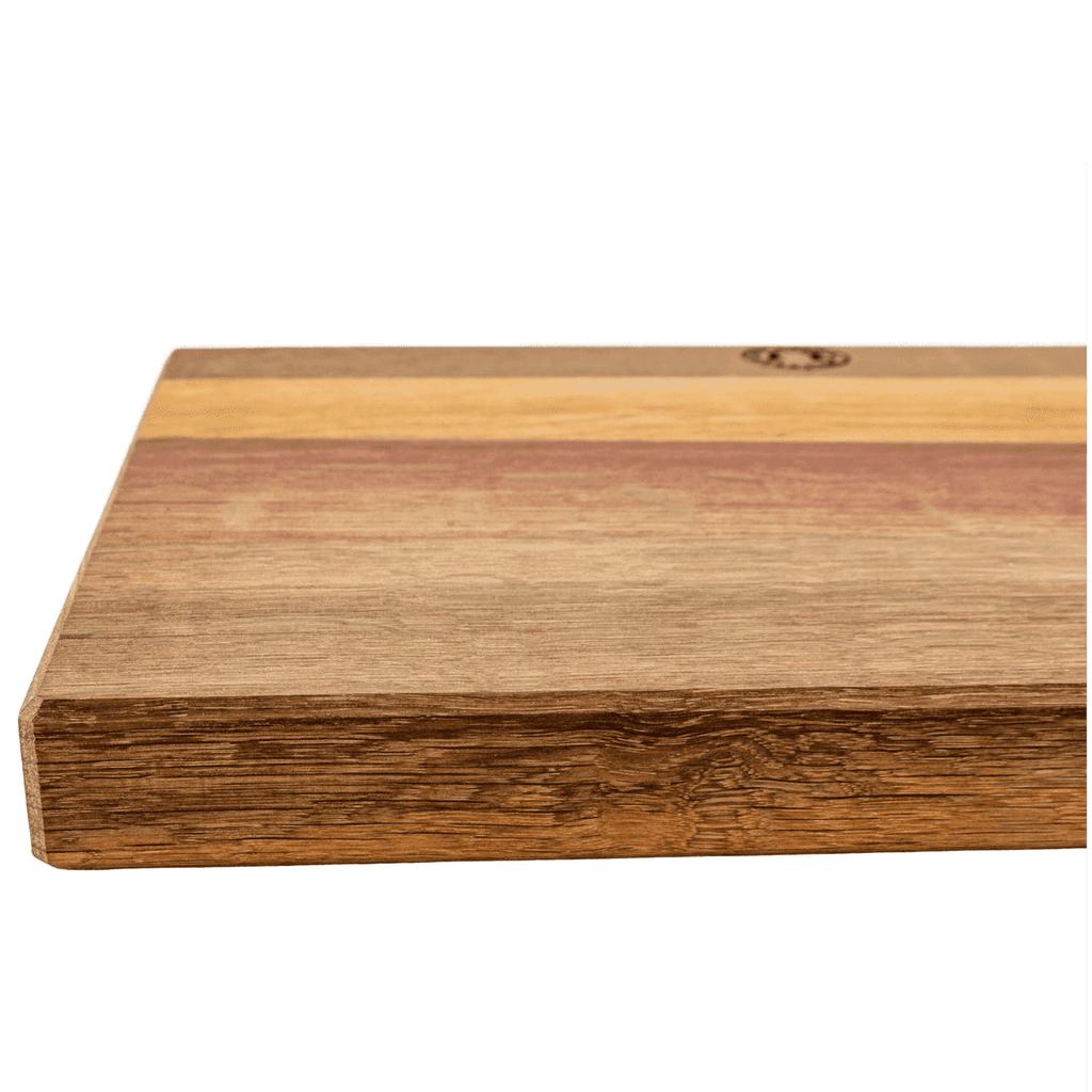 Eine Nahaufnahme des Palatina Frühstücksbretts 30x18 cm, Küchenbrett aus der Pfalz zeigt ein rechteckiges Schneidebrett aus Holz mit glatter Oberfläche. Das Brett weist verschiedene Holzmaserungen auf, darunter hellbraune, rötliche und hellbraune Streifen. Die sichtbare Kante zeigt die Dicke und Textur dieses exquisiten Küchenzubehörs.