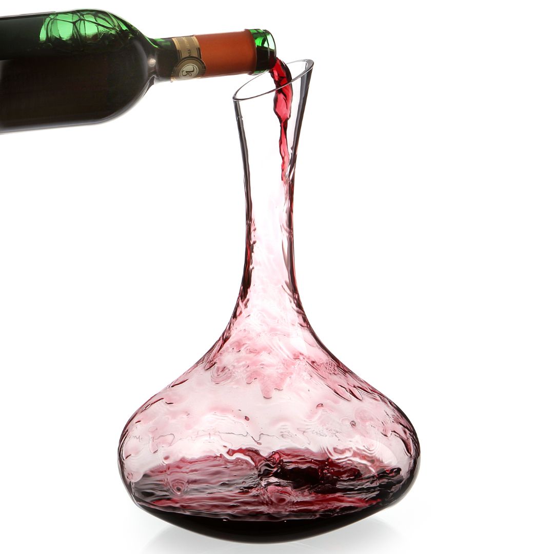 Rotwein wird in den Dekanter Pebble von Zieher aus Kristallglas - 1,8 L Handarbeit gegossen, wobei der Wein im Inneren des klaren Dekanters vor weißem Hintergrund wirbelt.