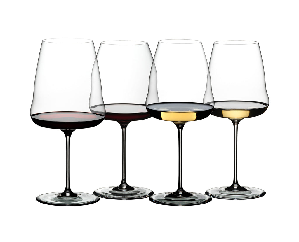 Abgebildet sind vier Gläser, die jeweils unterschiedlich hoch mit Rot- und Weißwein gefüllt sind. Die beiden Gläser links sind mit Rotwein gefüllt, während die beiden rechten Weißwein enthalten. Diese eleganten Champagnergläser Riedel Winewings mit Poliertuch in Geschenkverpackung sind nebeneinander vor einem schlichten weißen Hintergrund angeordnet und eignen sich perfekt für jeden Geschenkanlass.