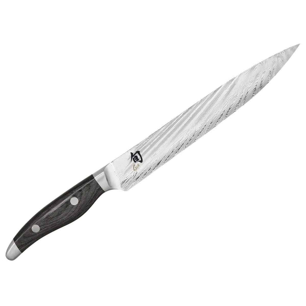 Das Kai Shun Nagare NDC-0704 ist ein ultrascharfes Schinkenmesser mit einer 23 cm langen Klinge aus 72 Lagen Damaststahl, die ein markantes Wellenmuster aufweist. Dieses elegante Messer hat einen dunklen, strukturierten Griff mit zwei Nieten für zusätzliche Stabilität und eine glänzende Metallendkappe. Es ist ideal für präzises Schneiden und passt perfekt zum mitgelieferten basaltgrauen Schneidebrett aus Eiche mit den Maßen 34x21 cm.