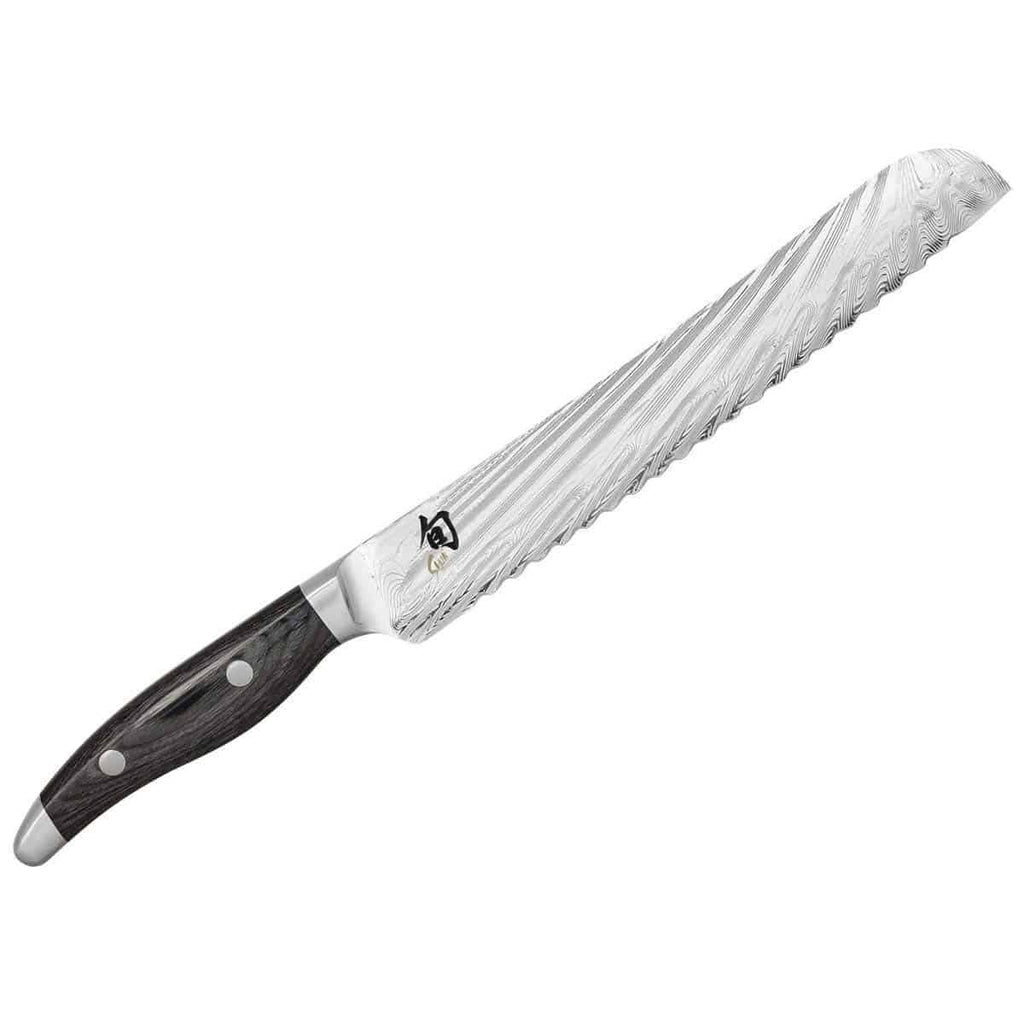 Ein Kai Shun Nagare NDC-0705 Japanisches Brotmesser mit einer 23 cm langen Klinge aus rostfreiem Stahl mit Wellenmuster und einem schwarzen ergonomischen Griff mit zwei silbernen Nieten ist auf einem weißen Hintergrund abgebildet und ergänzt das basaltgraue Eichen-Schneidebrett mit den Maßen 34 x 21 cm in Ihrer Küche perfekt.
