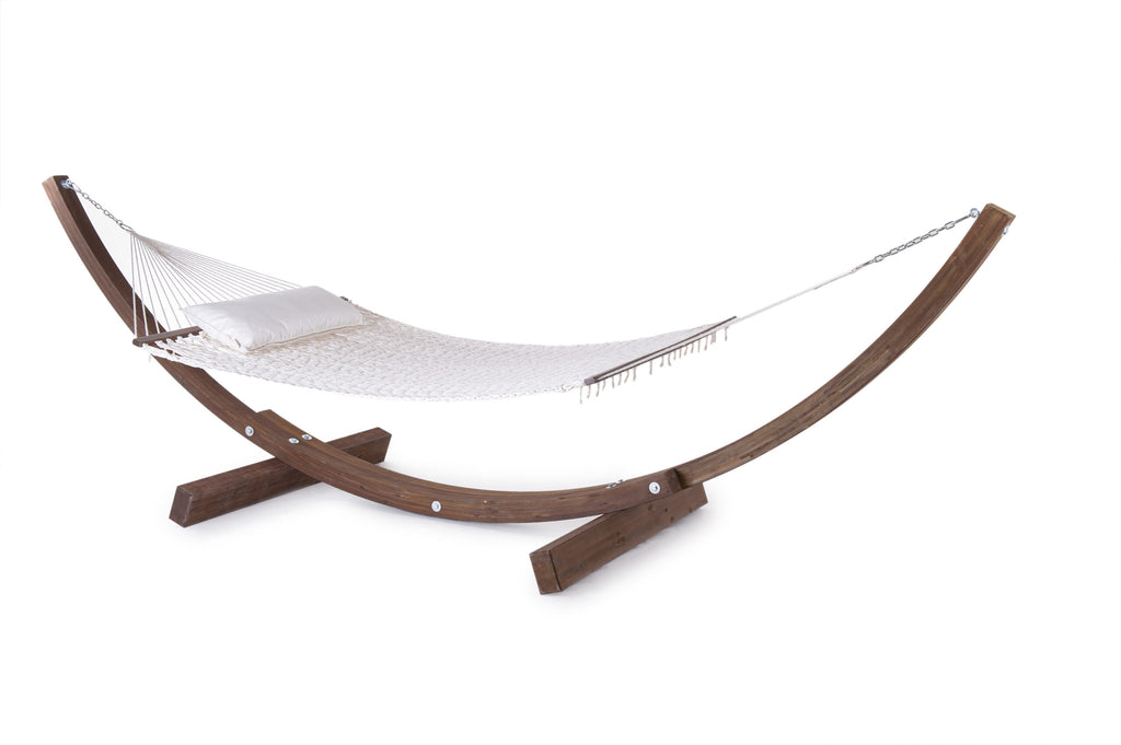 Eine Hängematte komplett mit Netzwerk, bestehend aus einem aufwendigen Netz und einem weißen Kissen, hängt zwischen zwei geschwungenen Holzständern. Das Set besticht durch ein klares, minimalistisches Design und ruht auf einem weißen Hintergrund, wodurch ein ruhiger Networking-Raum entsteht.