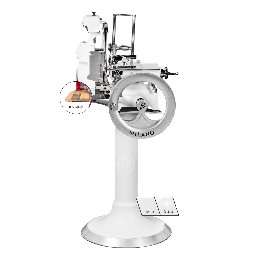 Die weiße Berkel Volano B114X - Exklusive Schwungradmaschine verfügt über ein Vintage-Design mit Standfuß, Handkurbel, Fassholzbrett, "MILANO"-Etikett, Metallakzenten und ist in den Ausführungen Matt oder Glanz erhältlich. Die Box mit der Aufschrift "inclusiv" ist ebenfalls abgebildet.