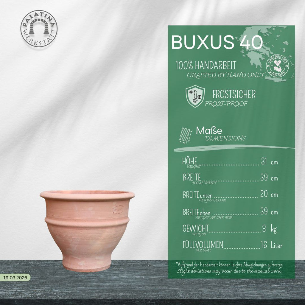 Ein handgefertigter rosafarbener Blumentopf aus Ton, "frostfestes Ton Pflanzgefäß 'Buxus', 40 cm", steht auf Holz neben einem grünen deutschen Schild, auf dem seine Eigenschaften, Abmessungen und sein Fassungsvermögen angegeben sind.