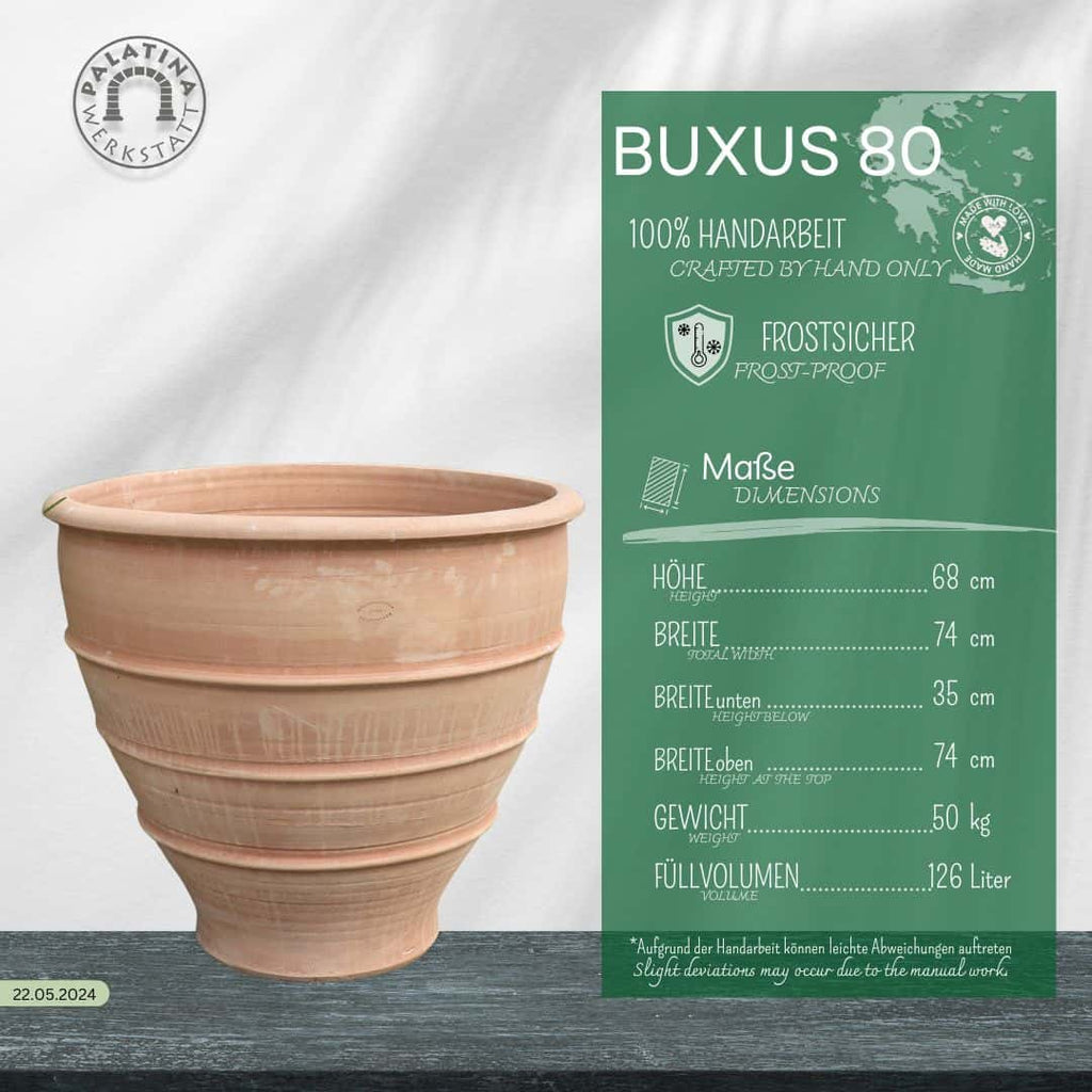 Das handgefertigte, winterharte Pflanzgefäß "Buxus", 60 cm, aus Terrakotta mit horizontalen Rillen ist frostfest, fasst 126 Liter und steht neben einem grünen Infopanel.
