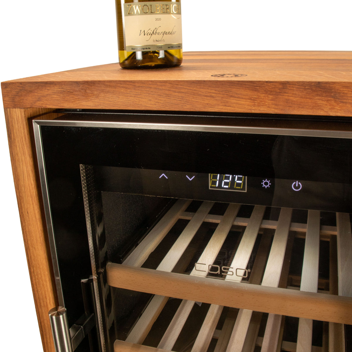 Eine Nahaufnahme eines eleganten Weinkühlschranks 2 Zonen CASO WineComfort 38 in Schwarz mit Fassholz-Umhausung. Die Kühlschranktür ist leicht geöffnet und gibt den Blick auf Holzregale im Inneren frei. Eine Flasche Weißwein steht auf dem Kühlschrank. Die digitale Temperaturanzeige zeigt „12,9“ Grad Celsius und unterstreicht die Präzision des CASO WineComfort-Systems.