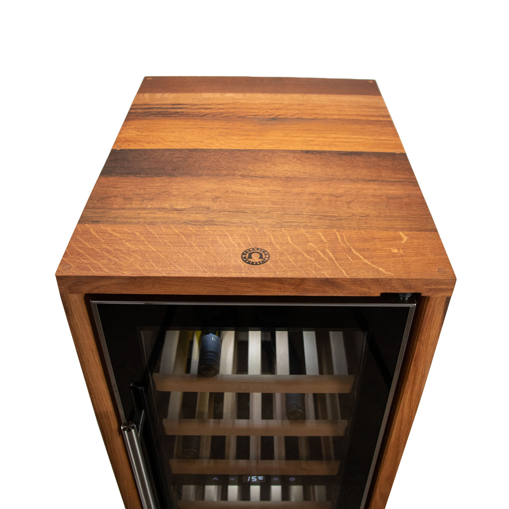 Der Weinkühlschrank 2 Zonen CASO WineComfort 38 in schwarz mit Fassholz-Umhausung ist ein hölzerner Weinkühlschrank mit Glastür und Metallgriff. Er verfügt über eine Holzplatte, mehrere Ablagen zur Aufbewahrung von Weinflaschen und zeigt im Inneren eine Temperatur von 15°C an.