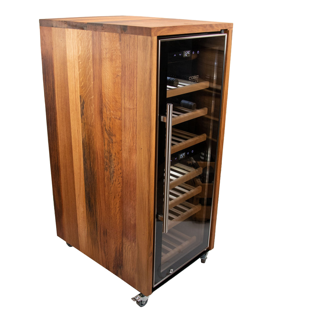 Ein stilvoller Weinkühlschrank 2 Zonen CASO WineComfort 38 in Schwarz mit Fassholzumhausung, mit einer Glasfronttür, die mehrere Holzregale im Inneren präsentiert. Das Gerät ist mit kleinen Lenkrollen für einfache Mobilität ausgestattet und verfügt über ein Anzeigefeld oben an der Tür, das die Temperatureinstellungen anzeigt. Mehrere Weinflaschen sind perfekt auf den Regalen untergebracht, was seine hervorragenden Weinlagerfähigkeiten demonstriert.