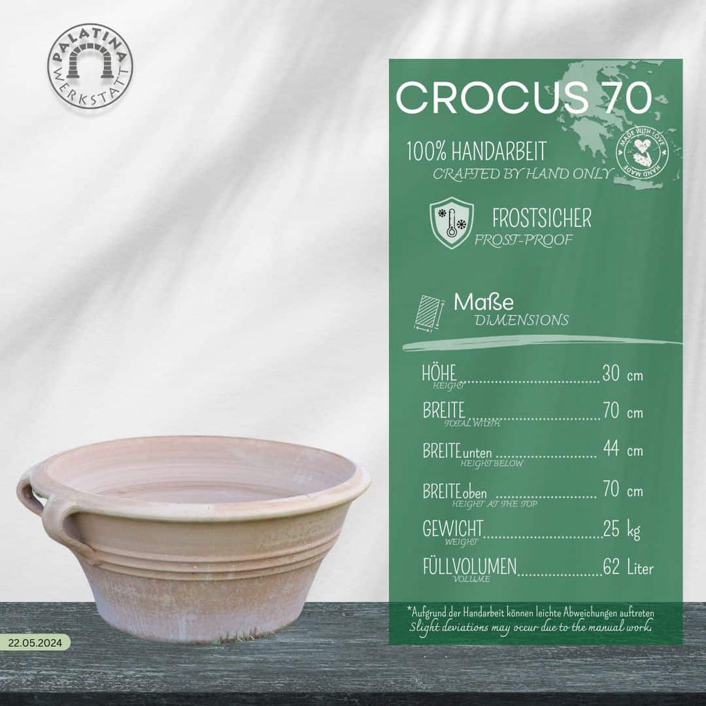 Eine hellbeige Kreta Keramik Terracotta Pflanz- und Wasserschale "Crocus", B=70 cm, mit zwei kleinen Henkeln steht auf einer dunklen Holzfläche. Eine grüne Infotafel weist darauf hin, dass sie frostsicher und handgefertigt ist und eine Breite von 70 cm hat.