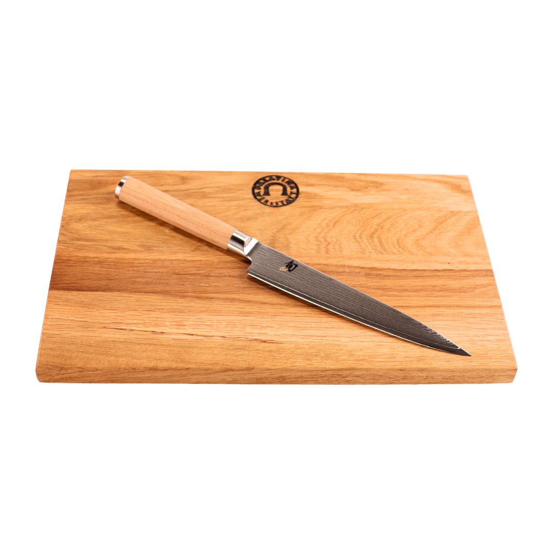 Das Kai Shun Classic White DM-0701W Allzweckmesser (15 cm Klinge) mit Holzgriff liegt diagonal auf dem Weinfass Küchenbrett (30x20 cm) mit Logo, das auf einem klaren, minimalistischen weißen Hintergrund steht.