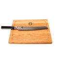 Das Kai Shun DM-0705 Brotmesser (23 cm Klinge) mit schwarzem Griff liegt auf einem 30x22 cm Eichenholzbrett mit Saftrille und rundem Logo - perfekt, wenn Sie ein japanisches Brotmesser kaufen möchten.