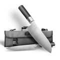 Das KAI Wasabi Black Set: Santoku, Allzweckmesser + Messertasche "THE MAGIC KAI WISHLIST 2025" wird mit einem Messer hochkant auf der grauen Tasche und dem anderen flach davor liegend präsentiert, beide mit schwarzen Griffen.