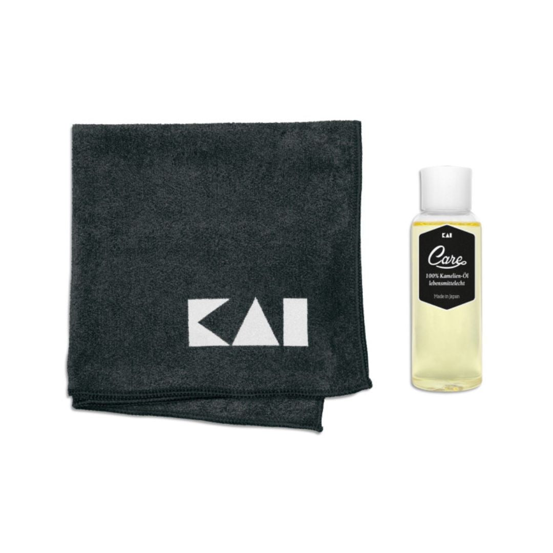 Das KAI Klingenpflegeset enthält ein schwarzes Mikrofasertuch mit weißem KAI-Logo und eine Flasche Kamelienöl aus Japan mit weißem Deckel und schwarzem Etikett - perfekt zur Messserpflege.
