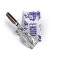 A Kai Shun Premier Tim Mälzer Nakiri Messer, TDM-1742, 14 cm Damaststahlklinge, mit dunklem Holzgriff liegt auf einer weißen Box mit Schleifgutschein "THE MAGIC KAI WISHLIST 2025", verziert mit blauer Rüstungsperson und Vogel.
