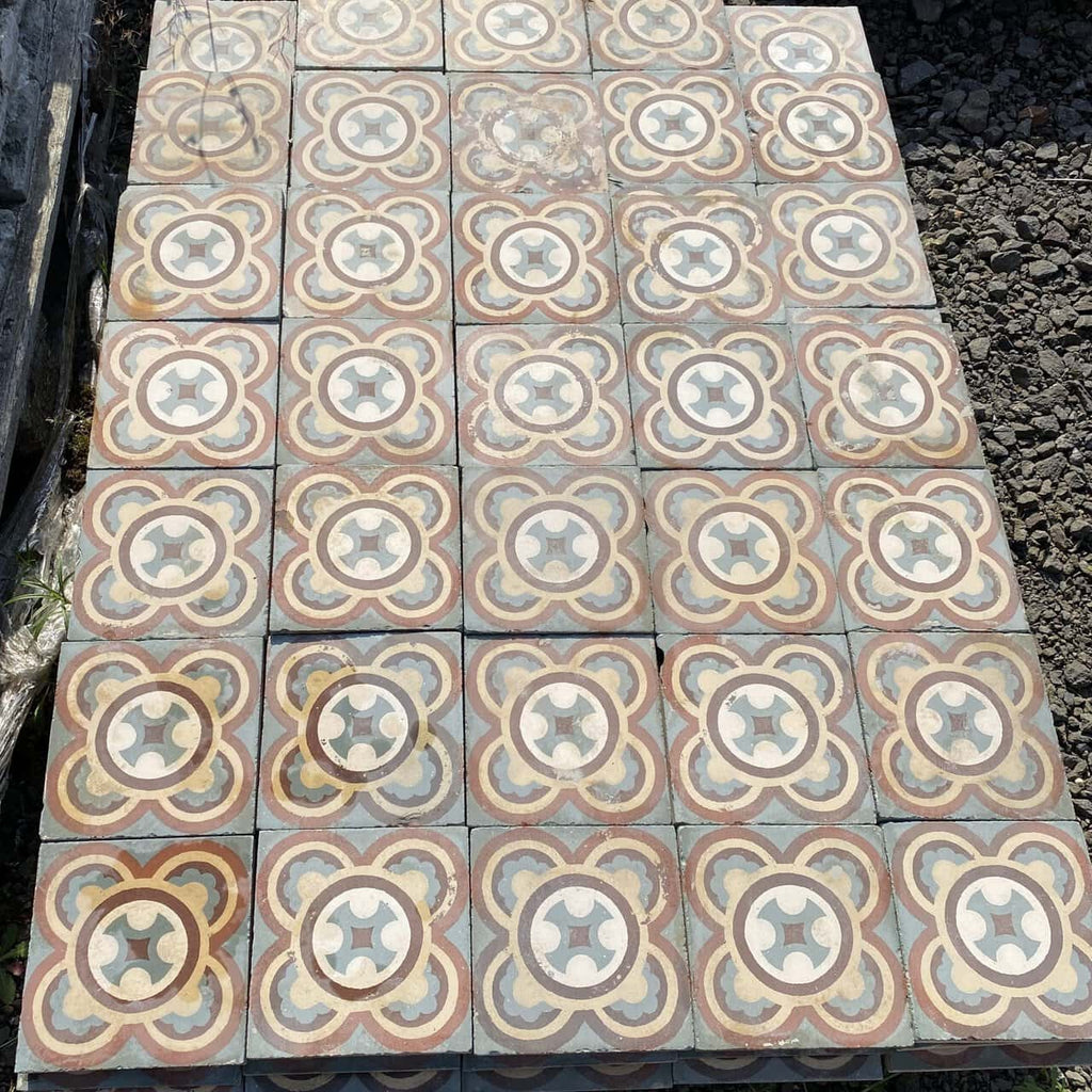 Ein Abschnitt mit aufwendig gemusterten Historischen Gründerzeitfliesen weist ein symmetrisches Design mit überlappenden Kreisen und Blumenmotiven in Beige-, Blau-, Rot- und Weißtönen auf. Die leicht abgenutzten 16,5 x 16,5 cm großen Fliesen verleihen ihrem Erscheinungsbild einen rustikalen und nostalgischen Charme und bedecken etwa 5,5 Quadratmeter.