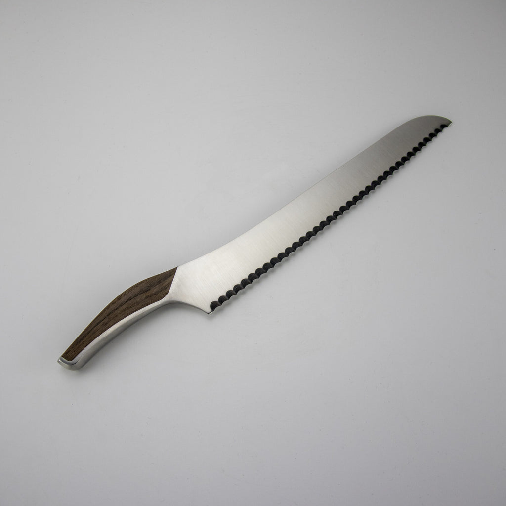 Ein Güde Synchros Brotmesser mit 32 cm langer Klinge und gezahnter Edelstahlklinge verfügt über einen Holzgriff und bietet ein geschwungenes ergonomisches Design für einfaches Schneiden. Zusätzlich enthält das Set ein 34x21 cm großes Schneidebrett. Das große Brotmesser ist auf einem schlichten weißen Hintergrund abgebildet.