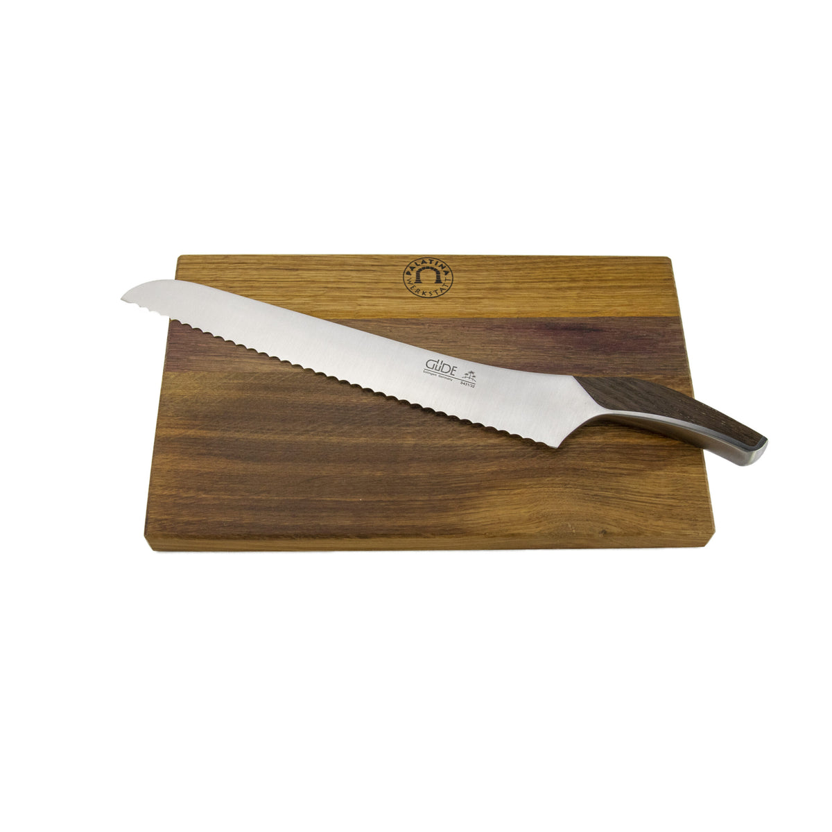 Auf einem hölzernen Fassholzbrett (34 x 21 cm) ist ein Güde Synchros Brotmesser mit einer 32 cm langen Klinge diagonal darüber angebracht. Das Messer hat eine Klinge aus rostfreiem Stahl und einen Griff aus dunklem Holz. In der Mitte des Schneidebretts ist ein kreisförmiges Logo eingraviert.