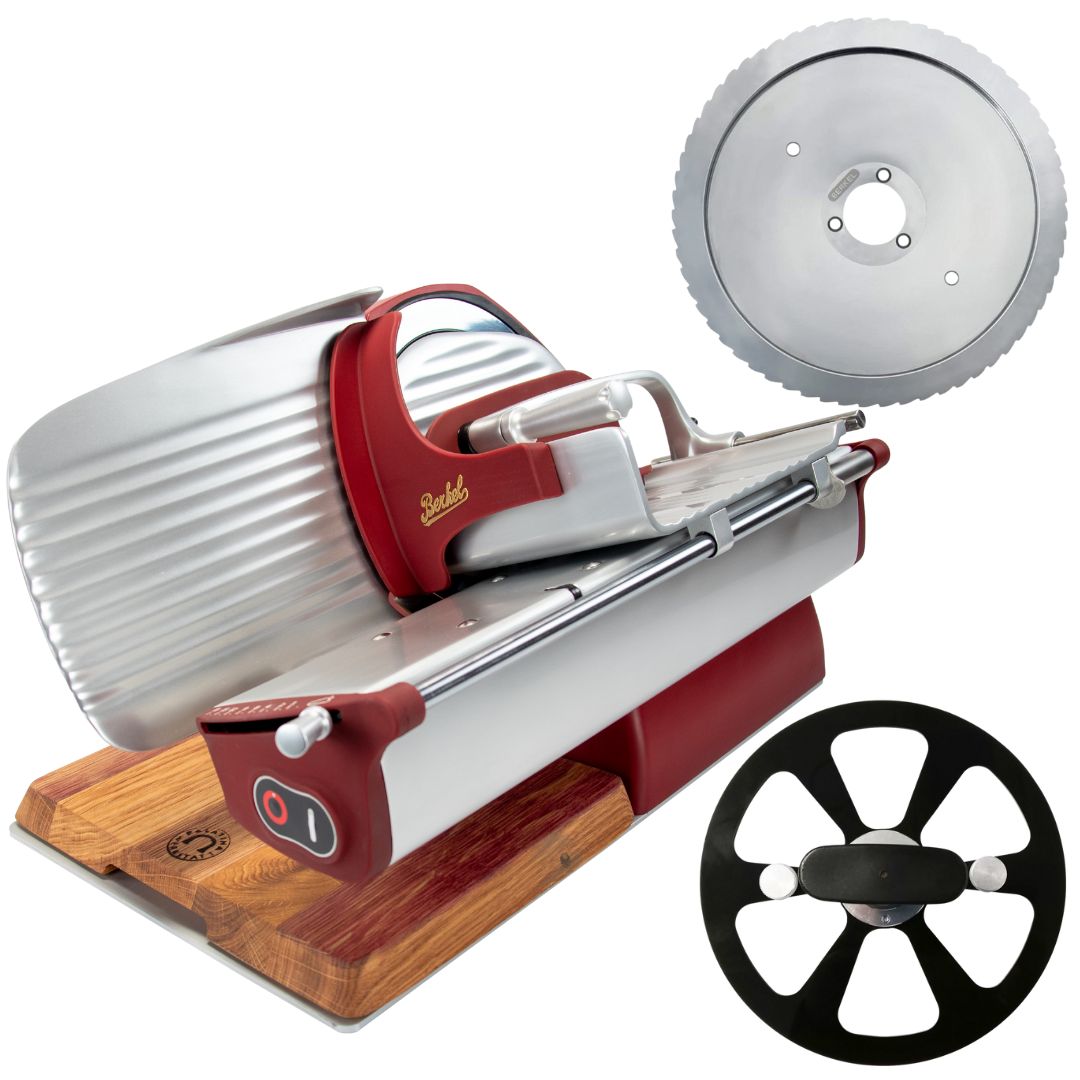 Die Berkel Home Line 250 Plus rot matt ist ein neues Modell einer Aufschnittmaschine mit einem handgefertigten Schneidebrett und einem Wellenschliff-Kit für Brot, das mit zwei Kreismessern gezeigt wird - einem speziell entworfenen und einem mit einem schwarzen Speichen-Design.