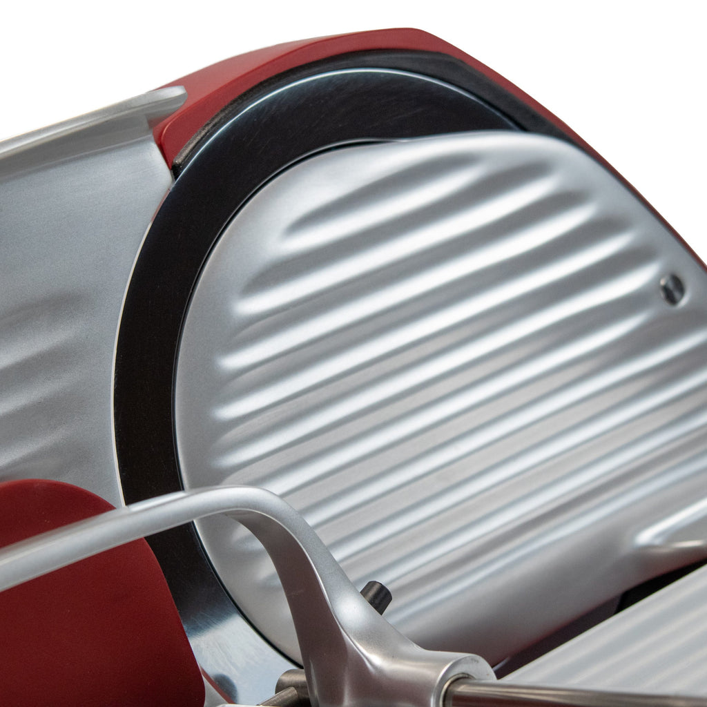Eine Detailansicht der Berkel Home Line 200 Plus rot MATT Aufschnittmaschine - Neues Modell, mit ihrem unverwechselbaren rot-silbernen Design mit runder Klinge und einem einzigartigen handgefertigten Schneidebrett.