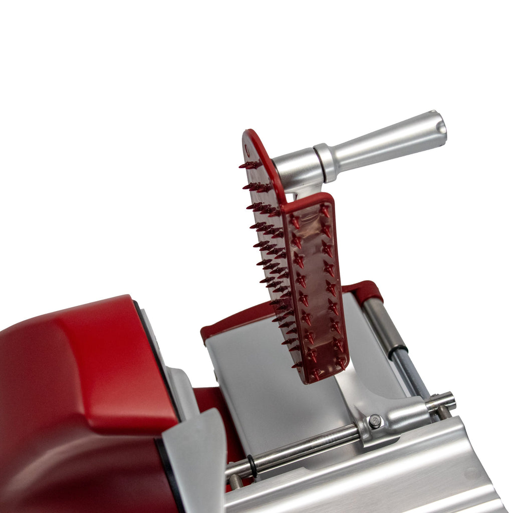 Eine Nahaufnahme der Berkel Home Line 200 Plus rot MATT Aufschnittmaschine - Neues Modell - Schneidemaschine, abgebildet mit rotem Schutzgitter und Metallgriff sowie einem einzigartigen handgefertigten Schneidebrett vor weißem Hintergrund.