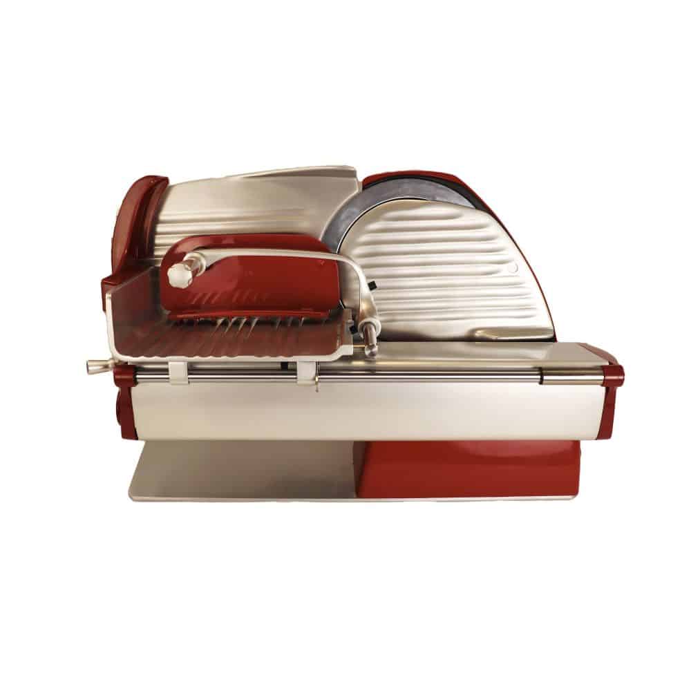 Die Berkel Home Line 200 Plus Rot, Aufschnittmaschine - Neues Modell - Schneidemaschine + 100 % handgefertigtes Schneidebrett Unikat ist eine rot-silberne Aufschnittmaschine im Vintage-Stil mit runder Klinge und manuellem Griff. Diese Maschine präsentiert sich in einem eleganten Retro-Design mit metallischem Finish, steht auf einem flachen Sockel und verfügt über eine Auffangschale für das geschnittene Fleisch.