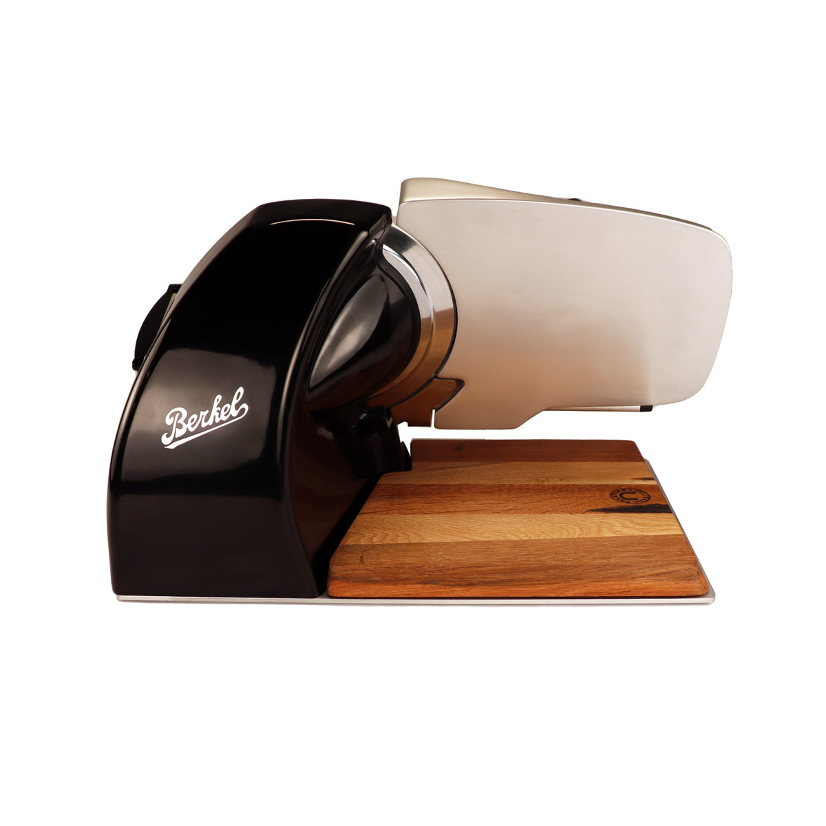 A Berkel Home Line 200 Plus schwarz Aufschnittmaschine, das neue Modell mit handgefertigtem Unikat-Schneidebrett und Wellenschliff-Bausatz für Brot, steht seitlich auf dem Holzbrett und präsentiert ihr elegantes Design sowie die scharfe Klinge.