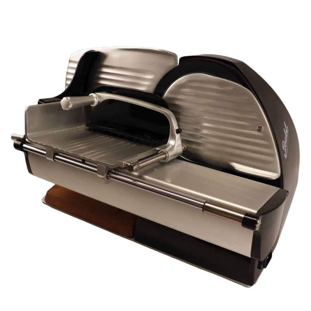 Ein moderner, silber-schwarzer elektrischer Allesschneider Berkel Home Line 200 Plus Schwarz mit elegantem Design. Dieses neue Modell verfügt über ein großes rundes Messer, ein integriertes Futterfach und einstellbare Dickeneinstellungen. Der Allesschneider wird durch ein einzigartiges, zu 100 % handgefertigtes Schneidebrett ergänzt und steht auf einem weißen Hintergrund.