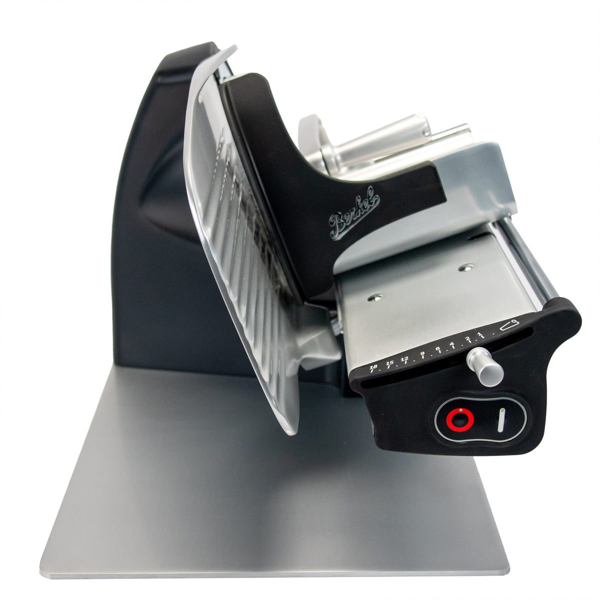 Die Berkel Home Line 200 Plus schwarz matt ist eine elektrische Schneidemaschine mit großer Klinge, verstellbarer Dickenskala und einem einzigartigen handgefertigten Schneidebrett und Wellenschliff-Kit für Brot - abgebildet auf einer Metalloberfläche.