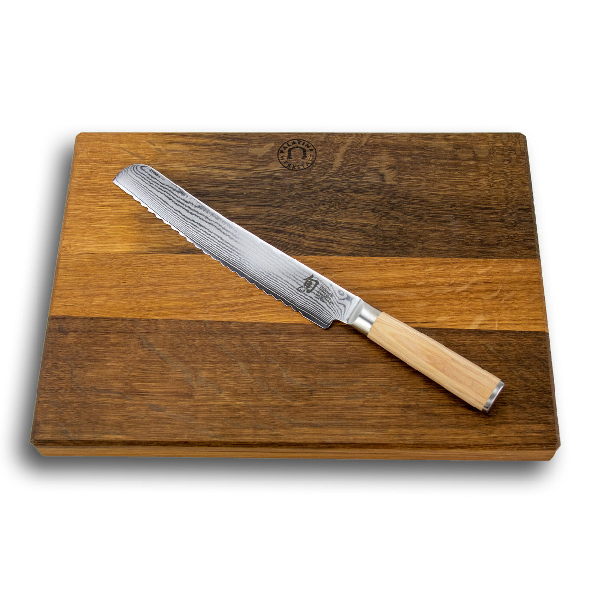 Ein Kai Shun Classic White DM-0705W Wellenschliffmesser mit Holzgriff liegt auf einem rechteckigen, handgefertigten Schneidebrett mit den Maßen 40x30 cm und zweifarbigem Holz. Die 23,0 cm lange Damastklinge weist eine gemusterte Textur auf und das Schneidebrett ist oben in der Mitte mit einem Emblem verziert.
