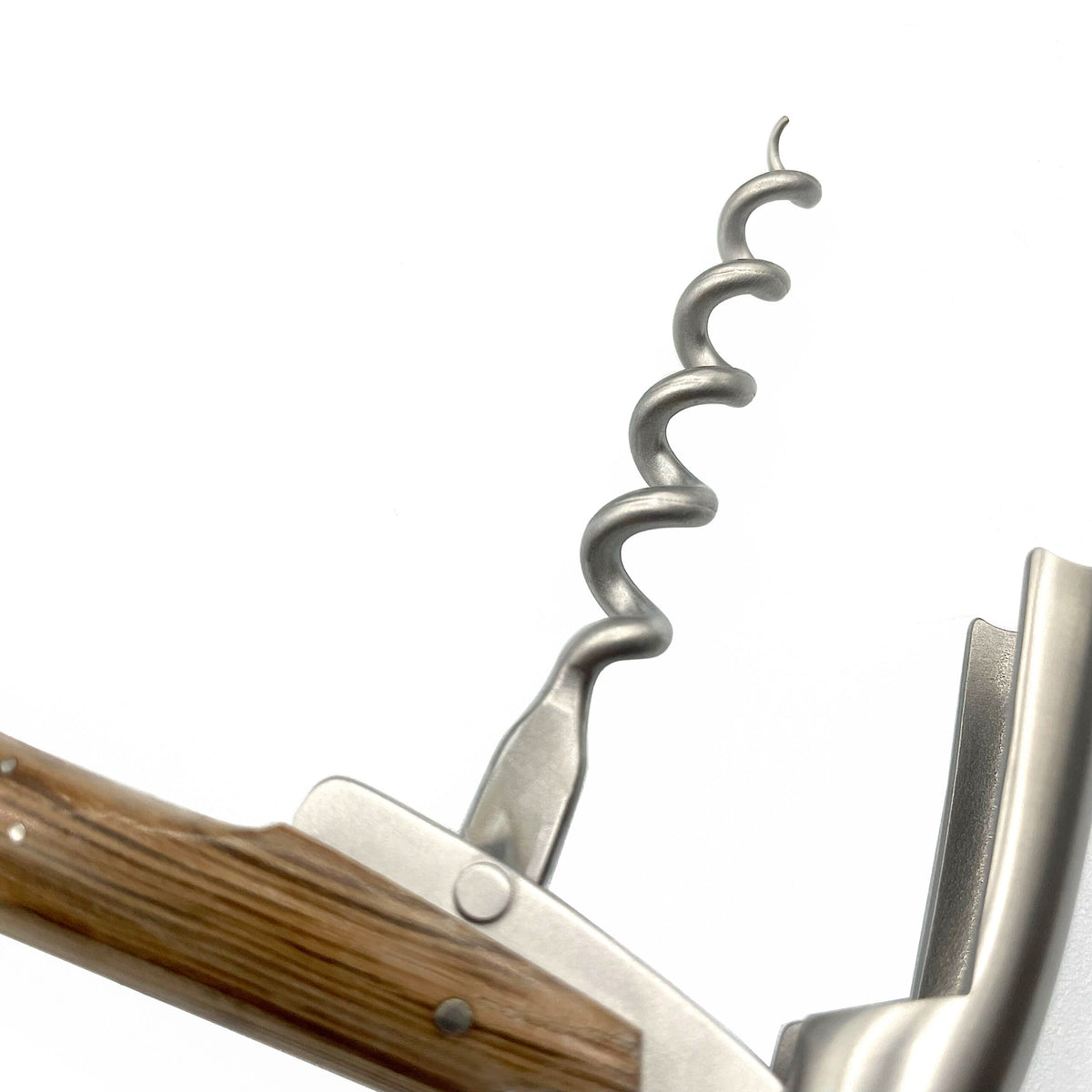 Eine Nahaufnahme des Forge De Laguiole Kellnermessers Sommelier | Mooreiche Rinde matt mit Holzgriff auf weißem Hintergrund. Die spiralförmige Metallschraube und der Klapphebelmechanismus sind deutlich sichtbar und unterstreichen das einfache und funktionale Design.