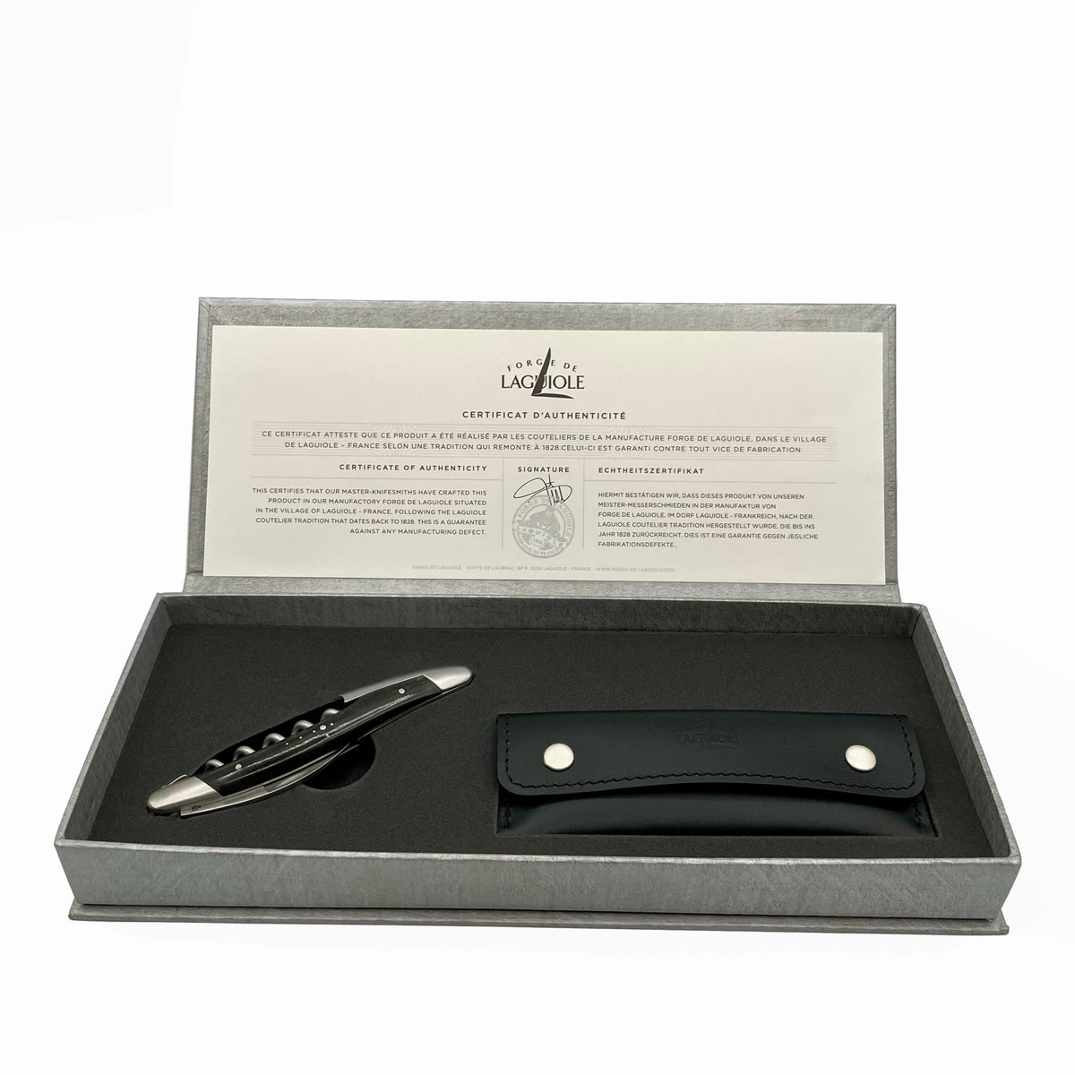 Wir präsentieren das Forge De Laguiole Kellnermesser Sommelier | Ebenholz matt – ein luxuriöses Set mit einem eleganten Laguiole-Korkenzieher mit mattem Ebenholzgriff und einer schwarzen Lederscheide. Die Box enthält außerdem ein Echtheitszertifikat von Forge De Laguiole, das sowohl auf Französisch als auch auf Englisch ausgestellt ist. Dieses exquisite Sommelier-Werkzeug ruht wunderschön auf einem hellgrauen Hintergrund.