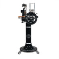Eine schwarze Berkel Volano B2 Schwungradmaschine in Schwarz steht auf einem Standfuß mit aufwendigen Details. Der Allesschneider verfügt über ein Handrad mit kunstvollen Mustern, ein einzigartiges Holzschneidebrett (Fassholzbrett Unikat) und Metallkomponenten. Der Markenname „Berkel“ ist auf der Maschine sichtbar.
