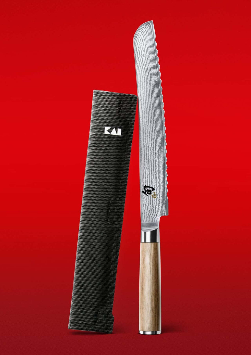 Das KAI X-MAS SELECTION DREAMBOX Shun Classic White Brotmesser mit Holzgriff steht aufrecht vor einem leuchtend roten Hintergrund, neben seiner eleganten schwarzen Klingenschutzscheide.