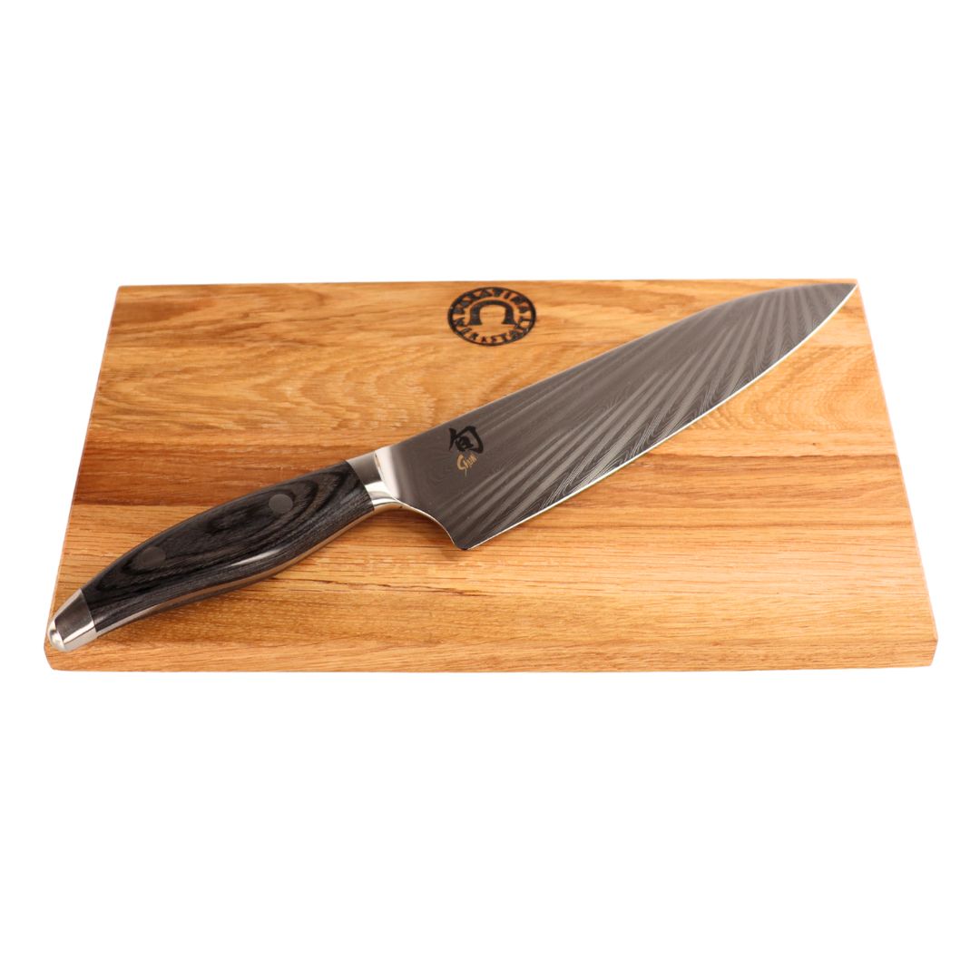 Das Kai Shun Nagare NDC-0706 Kochmesser (72-lagiger Damast, 20 cm Klinge) mit dunklem Holzgriff ruht auf einem 30x20 cm großen, basaltgrauen Eichenholz-Schneidebrett, das mit einem Logo versehen ist.