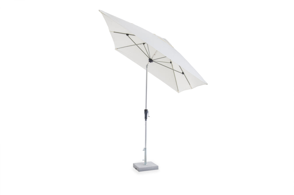 Ein weißer Sonnenschirm mit rechteckigem Schirmdach ist geöffnet und schräg geneigt. Dieser rechteckige verstellbare Sonnenschirm Lipari aus Aluminium, Teil der Lipari-Kollektion, wird von einer Aluminiumstange getragen und in einem quadratischen Sockel verankert. Der Schirm steht vor einem schlichten weißen Hintergrund.