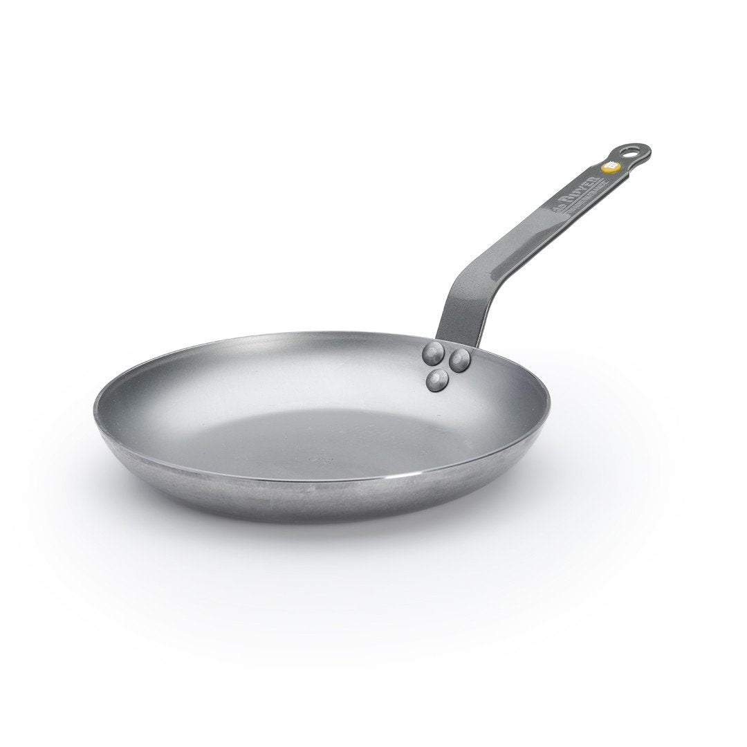 Eine silberne De Buyer Omelette-Pfanne Mineral B, 24 cm Dm, mit langem, abgewinkeltem Griff ruht auf weißem Grund. Die Pfanne mit glatter Oberfläche und abgerundeten Kanten sorgt für perfekte Omeletts und einwandfreie Garergebnisse.