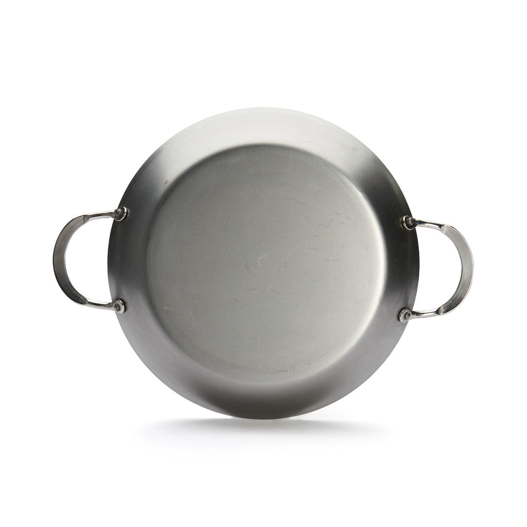 Eine runde De Buyer Paella-Pfanne Mineral B, 32 cm Dm, mit zwei seitlichen Griffen, von oben gesehen auf weißem Grund. Die glatte Stahloberfläche ist unlackiert.