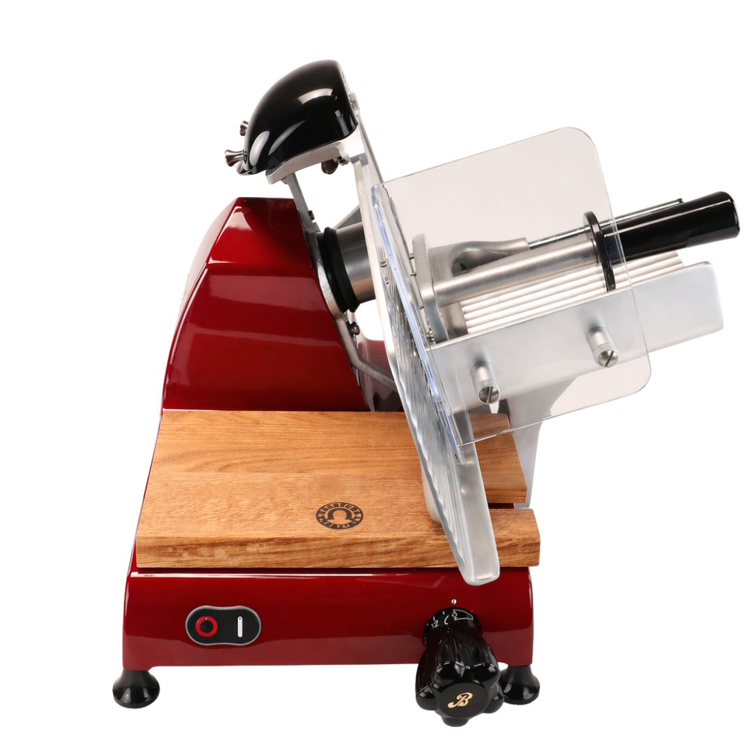 Eine Berkel Red Line 250 Rot Aufschnittmaschine mit durchsichtigem Schutzgitter, schwarzem Griff und Knopf, Palatina Einlegebrett und integriertem Spitzer, dargestellt von der Seite auf weißem Hintergrund.