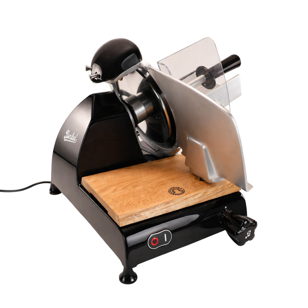 Abgebildet ist eine Berkel Red Line 250 Schwarz Profi-Aufschnittmaschine mit einer 25 cm langen silbernen Klinge, einem Holzschneidebrett, einem transparenten Schutzgitter und einem Netzschalter auf weißem Hintergrund.