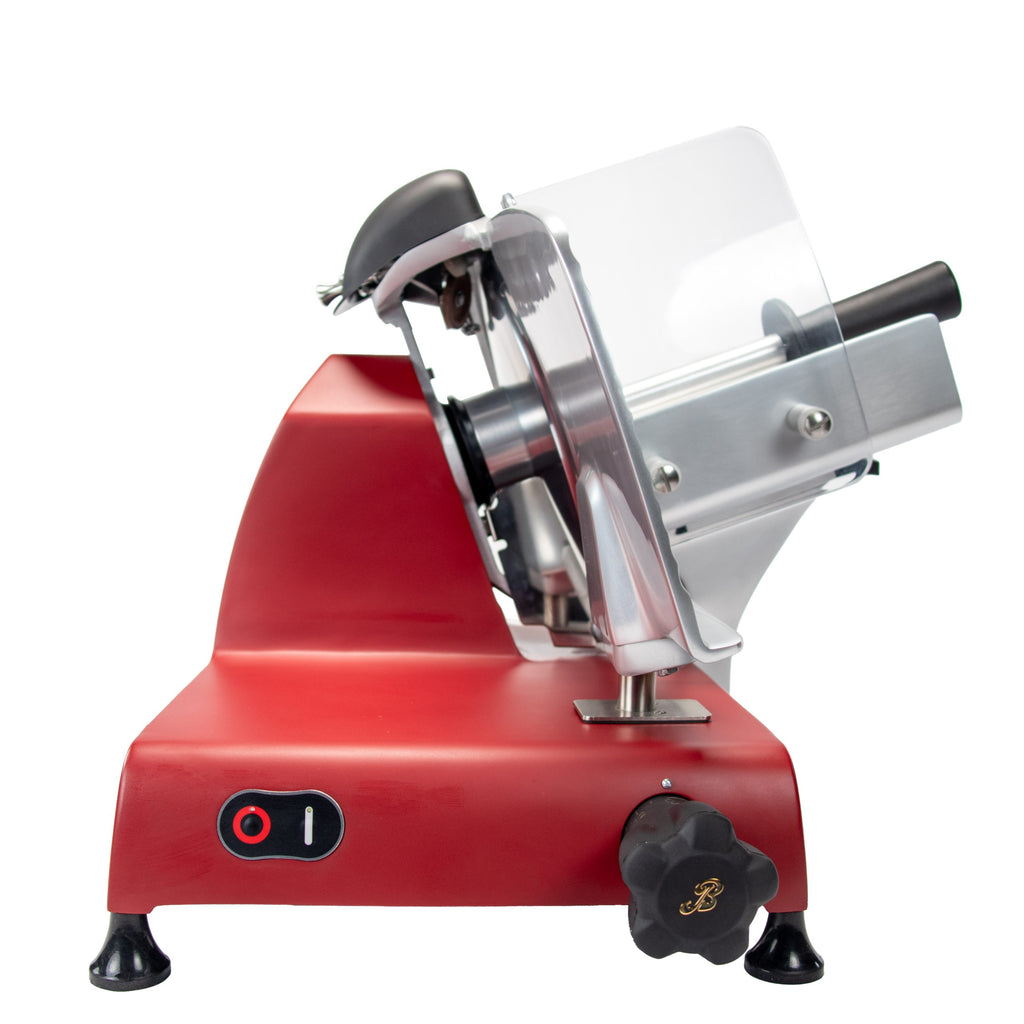 Der elegante Berkel RedLine 250 MATT ist ein roter elektrischer Fleischschneider mit transparentem Schutz, verstellbarem Knopf und schwarzem Tablett. Er verfügt über ein abgewinkeltes Klingengehäuse und einen praktischen Ein-/Ausschalter an der Basis und steht mit seinem Fassholzbrett anmutig vor einem weißen Hintergrund.