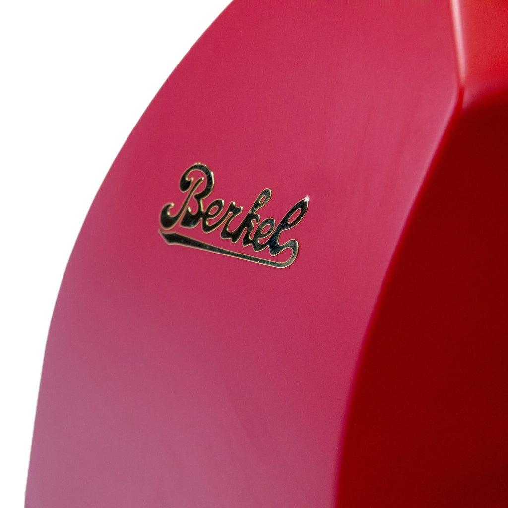 Eine Nahaufnahme des eleganten, roten Berkel RedLine 250 MATT rot mit Fassholzbrett zeigt den in Gold glänzenden Namen „Berkel“, der die Präzision der Serie widerspiegelt. Seine glatte, matte Oberfläche verstärkt seinen eleganten Reiz.