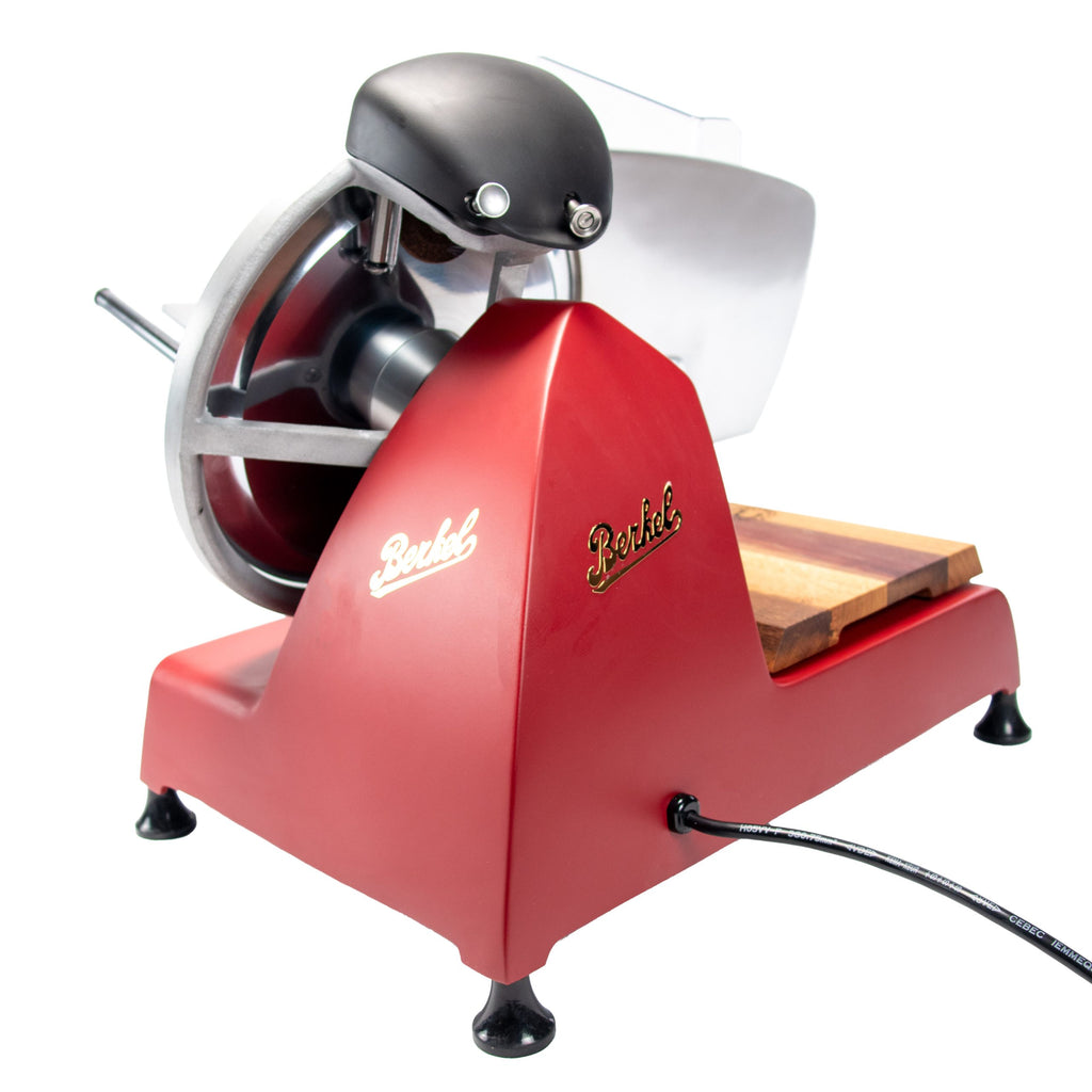 Das Berkel RedLine 250 MATT rot mit Fassholzbrett verfügt über eine Metallklinge, eine Holzablage, einen schwarzen Griff und ein Netzkabel. Sein Vintage-Design wird elegant vor einem weißen Hintergrund hervorgehoben.