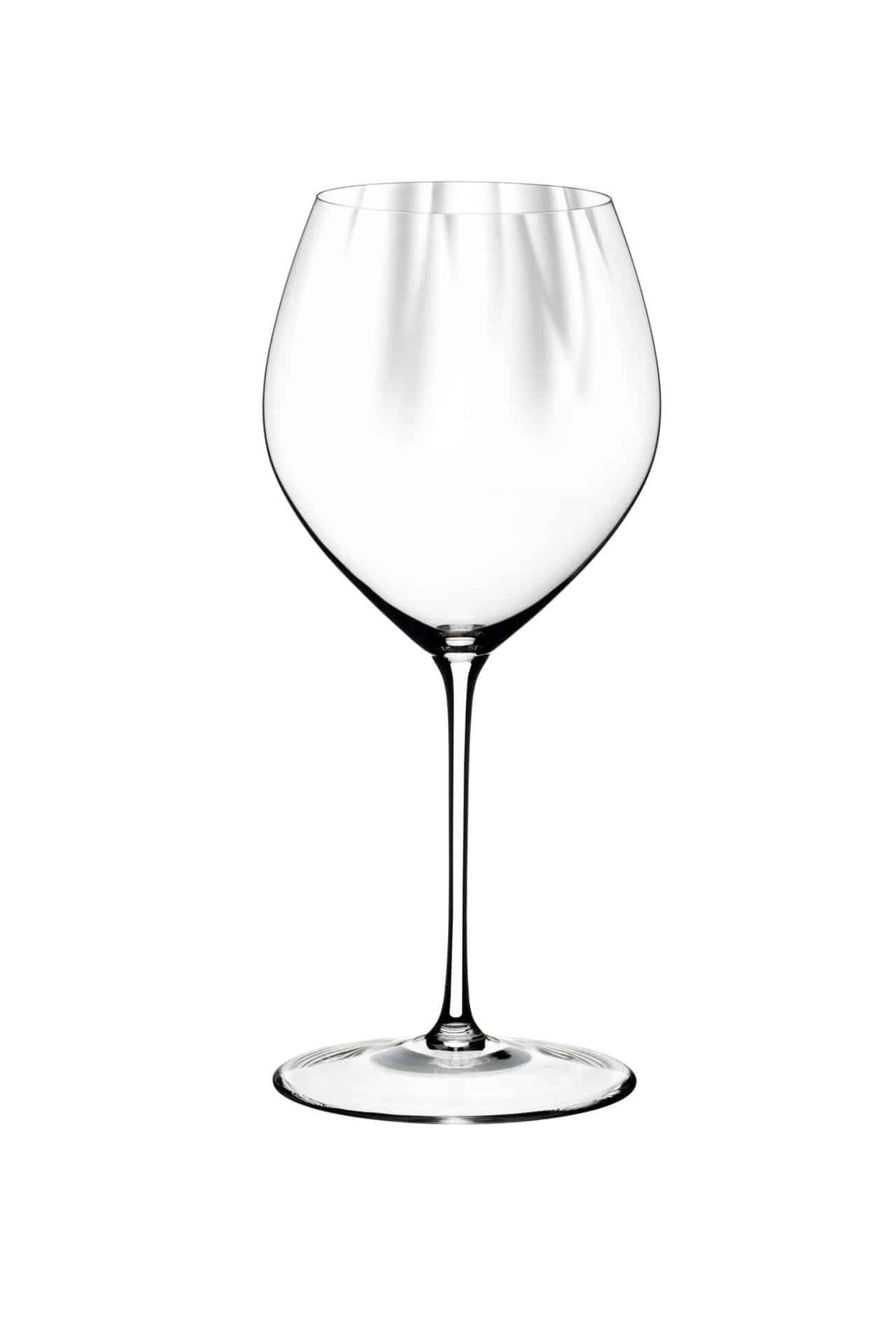 Ein klares, leeres Weißweinglas Riedel Performance Chardonnay mit langem Stiel und breiter, geschwungener Schale steht zentriert vor einem weißen Hintergrund. Das Chardonnay-Glas ist makellos und elegant und reflektiert das Licht auf seiner glatten Oberfläche.